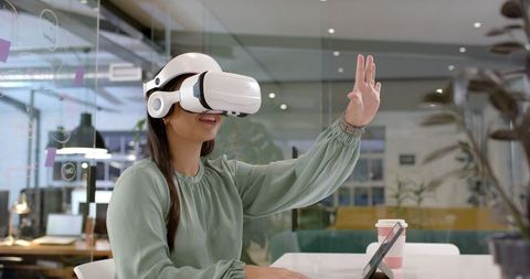 Asian businesswoman engaging with virtual reality in office