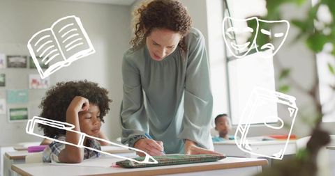 Teacher leaning over desk helping student writing in sunlit classroom