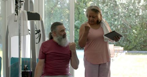 Senior Couple Considering Fitness Routine at Home with Tablet