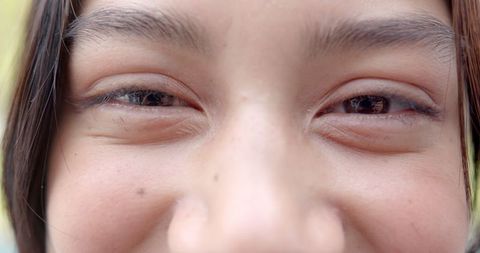 Close-up Portrait of Smiling Biracial Teen with Radiant Eyes Outdoors
