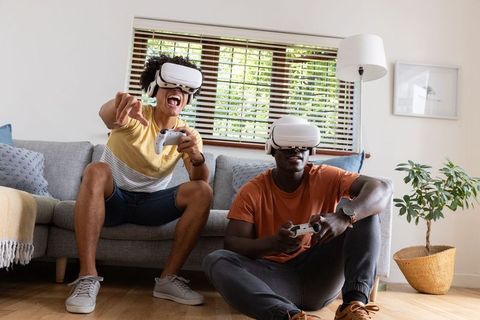 Diverse Friends Gaming in Living Room with VR Technology and Controllers