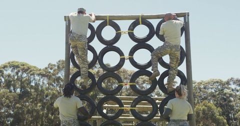 Soldiers Climbing Tyre Wall on Obstacle Course in Sunlit Setting - Download Free Stock Images Pikwizard.com
