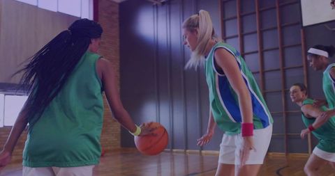 Basketball Athletes Competing on Indoor Court in Green Jerseys