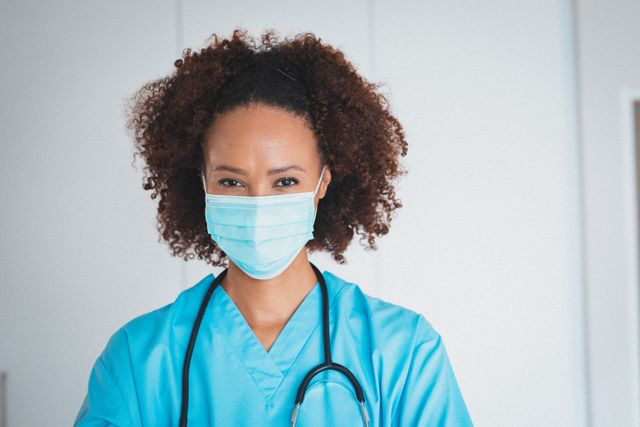 Portrait of biracial doctor with stetoscope wearing face mask. professional healthcare worker during coronavirus covid 19 pandemic.