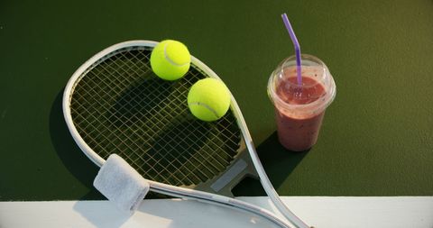 Tennis gear with refreshing berry smoothie on court surface