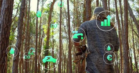 Man carrying firewood amidst forest with eco-friendly icons