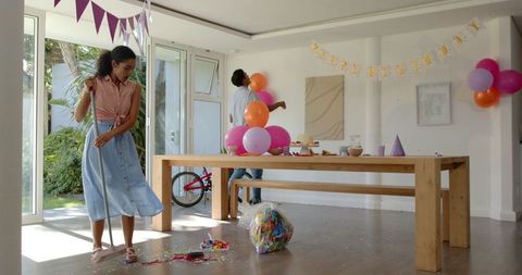 Cleanup after party, couple tidying bright decor