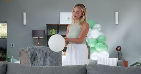 Woman Preparing Balloon Decorations for Birthday Celebration at Home