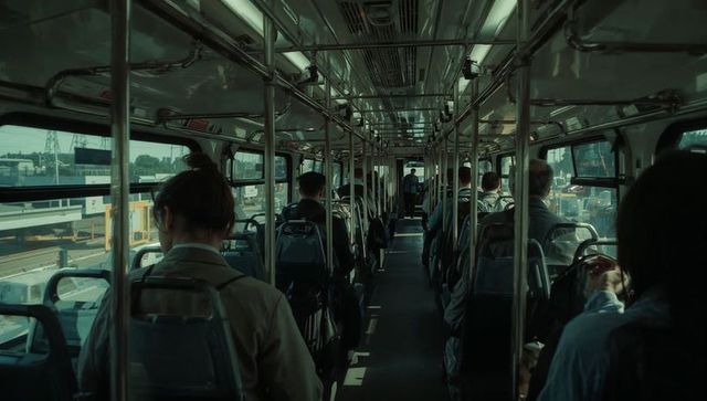Female commuter sitting on city bus holding backpack during urban morning commute