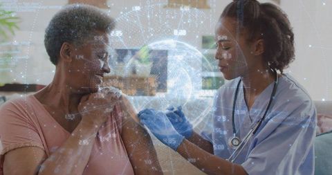 Home nurse administering vaccine to older woman with virtual globe data overlay