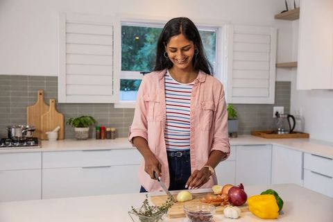 Vibrant home cooking scene with woman chopping vegetables