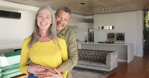 Senior Couple Embracing in Modern Open-Plan Living Room