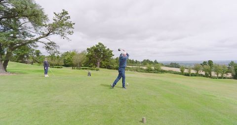 Senior Couple Enjoys Golf Game Amidst Stunning Landscape