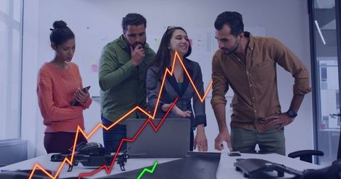 Diverse team collaborating around laptop with growth charts and drone on conference table