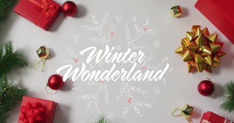 Winter wonderland holiday flatlay with centered script, red presents, gold bow, evergreen