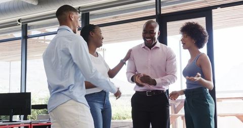 Diverse team celebrating success together in office setting