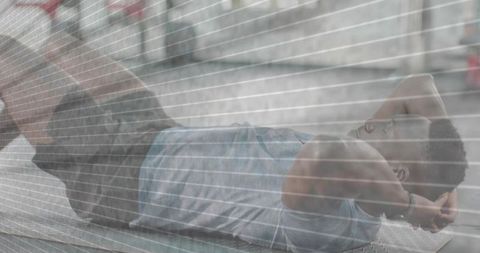 Man performing core crunches on urban bench by graffiti wall during outdoor fitness training