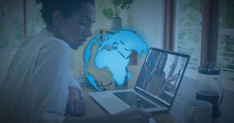 Woman taking notes at laptop with holographic globe for remote work and global learning