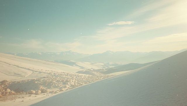 Serene Winter Landscape with Snow-Covered Hills and Distant Peaks