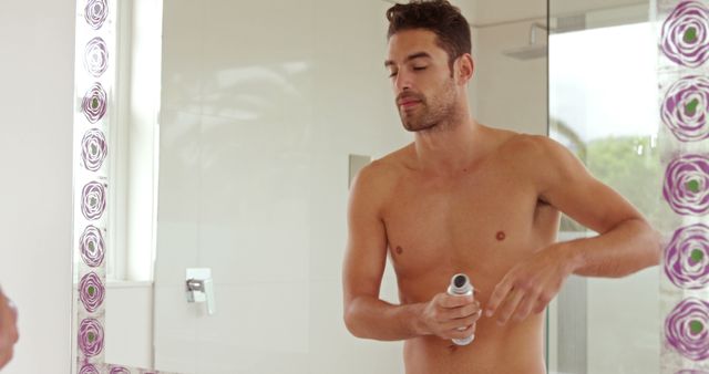 Shirtless Young Man Applying Deodorant in Modern Bathroom - Download Free Stock Images Pikwizard.com