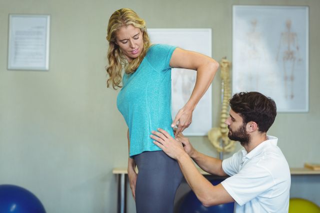 Physiotherapist examining womans back in clinic