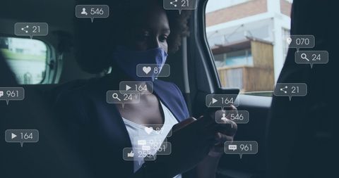 African American Woman Using Smartphone Amid Social Media Cloud in Car