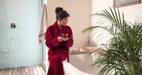 Serene Morning: Woman in Burgundy Bathrobe Enjoying Tea