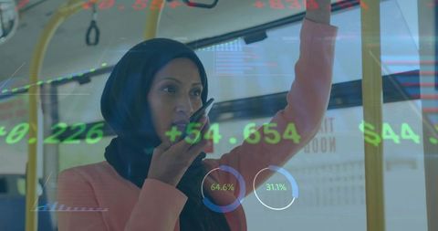 Woman in hijab speaking on phone while commuting on tram with stock market data overlay