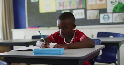 African American Schoolboy Writing in Classroom Setting - Download Free Stock Images Pikwizard.com