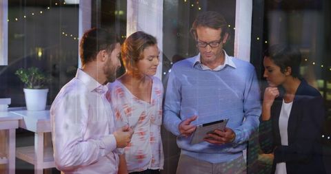 Diverse Team Analyzing Financial Data on Tablet Screen