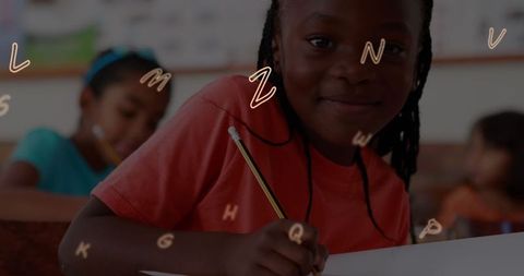Schoolgirl Enjoying Learning With Floating Letters in Classroom