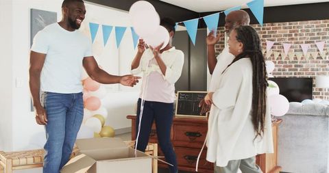 Excited Family Celebrating Baby Shower with Balloons in Living Room