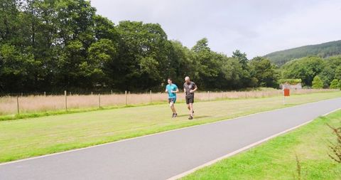 Two People Jogging on Lush Green Park Trail for Wellness and Fitness - Download Free Stock Images Pikwizard.com