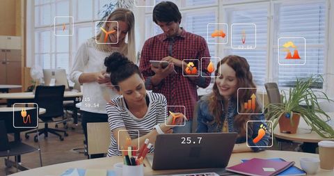 Young team collaborating around laptop with ar analytics and tablet in bright coworking hub
