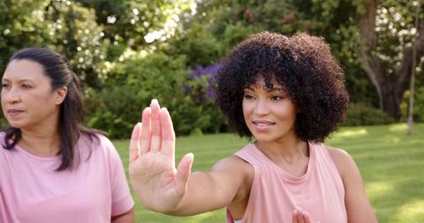 Women practicing yoga and mindfulness in outdoor garden minimalist aesthetic