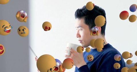 Tech-savvy man interacting with digital emojis in minimalistic space