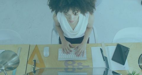 Overhead view creative professional typing at minimalist wooden desk with tablet and sketch tools