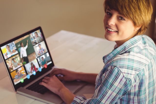 Smiling caucasian girl using laptop for video call, with diverse elementary school pupils on screen. communication technology and online education, digital composite image.
