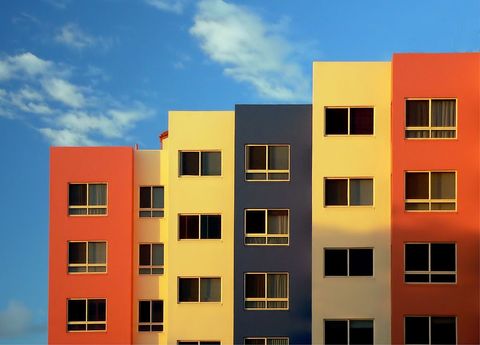 Colorful modern condo apartment building against blue sky