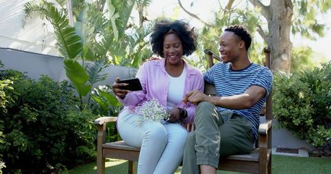 Joyful Couple Taking Selfie on Sunny Garden Bench
