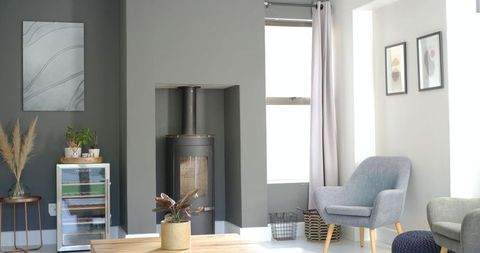 Cozy scandinavian living room featuring black wood stove and minimalist gray interior