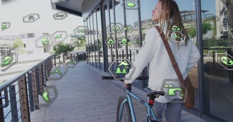 Eco-conscious urban cyclist walking with bicycle near glass windows