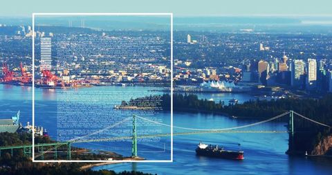 Aerial view of green suspension bridge spanning busy harbor with cargo ship and skyline