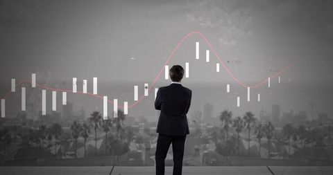 Businessman analyzing financial graphs over cityscape
