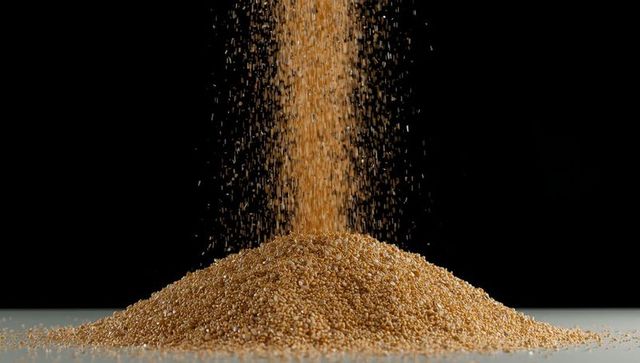 Cascading golden grains on reflective platform