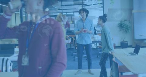 Young professionals collaborating in open-plan office during casual discussion and teamwork