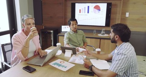 Diverse Coworkers Collaborating on Business Analysis in Modern Office