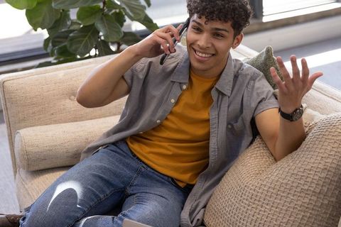 Young Man Conversing on Smartphone at Home, Relaxed Atmosphere