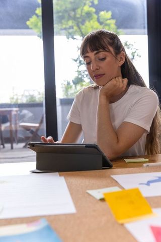 Focused woman using tablet in contemporary office setting