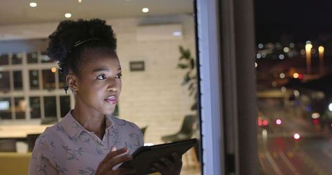 Businesswoman Planning Strategic Projects Late at Night with Tablet